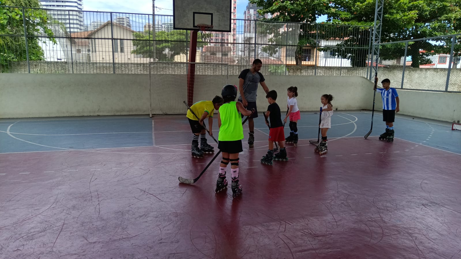 Treinador ensinando crianças na Escolinha de Patinação e Hockey